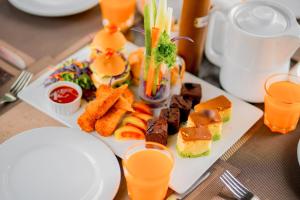 a plate of food on a table with orange juice at Miridiya Lake Resort in Anuradhapura