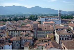 a city with buildings and mountains in the background at Authentic Tuscan Studio in Lucca with Private Patio in Lucca