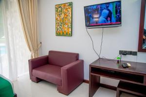 a living room with a chair and a tv at Miridiya Lake Resort in Anuradhapura