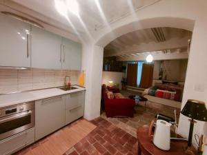 a kitchen with a red chair and a living room at Authentic Tuscan Studio in Lucca with Private Patio in Lucca