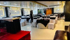 a dining room with tables and white and black at Hotel SP international Lucknow in Lucknow