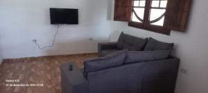 a living room with a couch and a television at Aconchego das Araras in Sirinhaém