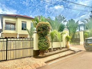 a fence in front of a house with plants at Dash-8 in Kigali