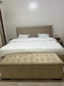 a bedroom with a large bed with a tufted headboard at Dash-8 in Kigali