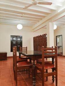 a dining room with a table and chairs at La Maison D'Ellappa in Pondicherry +4 photos