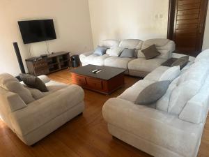 a living room with two couches and a tv at Dash-8 in Kigali