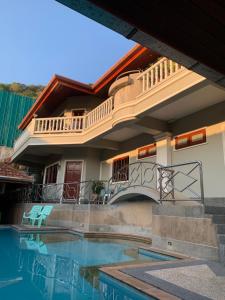 a house with a balcony and a swimming pool at Scan House Apartment in Karon Beach