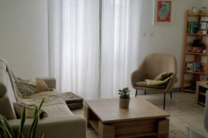 a living room with a couch and a chair and a table at Le Frangipanier in La Possession