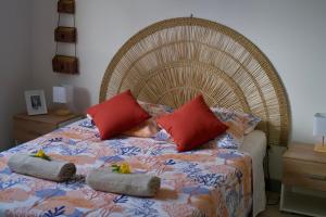 a bedroom with a bed with two pillows on it at Le Frangipanier in La Possession