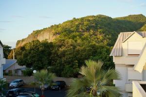 a mountain with cars parked in a parking lot at Le Frangipanier in La Possession