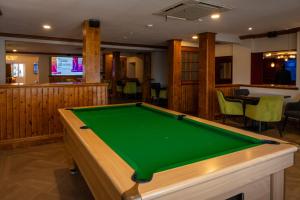 a pool table in a room with a bar at The Oakwood Hotel in Gloucester