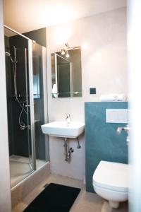 a bathroom with a sink and a toilet and a shower at Lakeside Lodge mit Seeblick am Kranichsee in Goslar +10 photos