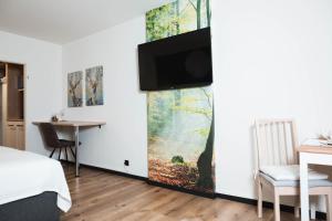 a bedroom with a flat screen tv on a wall at Lakeside Lodge mit Seeblick am Kranichsee in Goslar