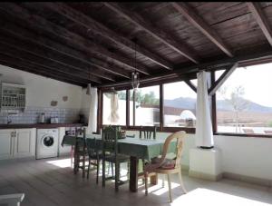 a dining room with a green table and chairs at El aceitunal private pool in Puerto del Rosario