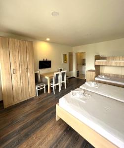 a room with two beds and a kitchen and a table at Apartments Gloria in Budva