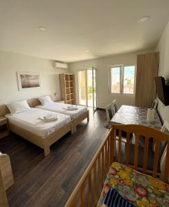 a bedroom with two beds and a balcony at Apartments Gloria in Budva