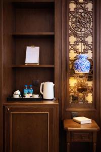 a cupboard with a coffee maker and a vase at Eli Rina Hotel in Hanoi