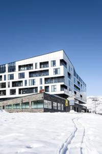 ein Gebäude mit Schnee davor in der Unterkunft Hôtel VoulezVous by Les Etincelles in Tignes
