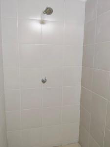 a white tiled shower with a light on it at Kayangan Suite - Home Studio in Kangar
