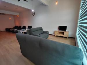 a living room with a couch and a tv at Kayangan Suite - Home Studio in Kangar