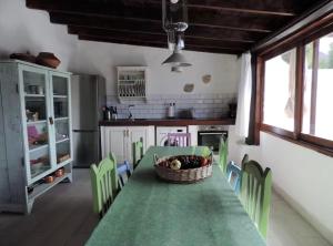 a kitchen with a table and chairs with a basket on the table at El aceitunal private pool in Puerto del Rosario