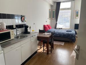 a kitchen with a table and a bed in a room at Appartement centrum Groningen in Groningen +5 photos