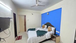 a room with a bed with a blue wall at Rajdhani Resort Lonavala in Lonavala