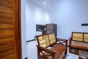 a living room with two chairs and a refrigerator at Meys Hiriketiya in Dickwella