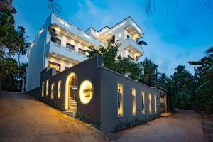 a white building with lights in front of it at Meys Hiriketiya in Dickwella