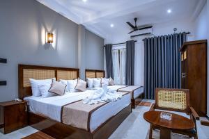 a hotel room with two beds and a chair at Meys Hiriketiya in Dickwella +100 photos