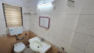 a bathroom with a sink and a toilet and a mirror at Rajdhani Resort Lonavala in Lonavala