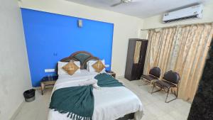 a bedroom with a bed with a blue wall at Rajdhani Resort Lonavala in Lonavala