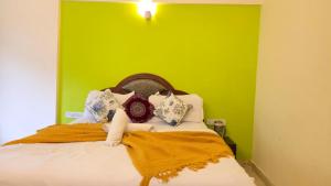 a bedroom with a bed with a green wall at Rajdhani Resort Lonavala in Lonavala