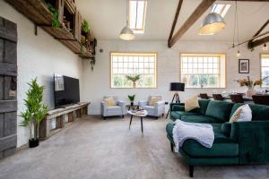 a living room with a green couch and a tv at The Freston Forge in Freston