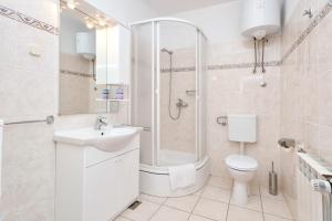 a bathroom with a shower and a toilet and a sink at Apartment Oaza in Vrboska +14 photos