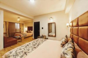 a hotel room with a bed and a living room at Avira Hotel in Gangtok