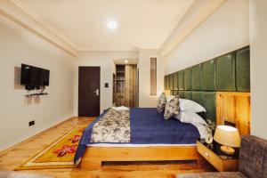 a bedroom with a large bed and a tv at Avira Hotel in Gangtok