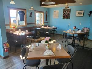 a restaurant with tables and chairs and blue walls at The Orca Inn in Alert Bay