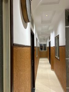 a hallway in a hospital with a clock on the wall at Hotel JT in Indore