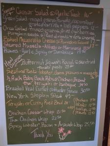 a chalkboard with a list of food items on it at The Orca Inn in Alert Bay +7 photos