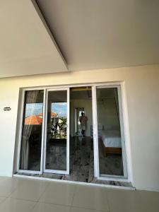 a room with sliding glass doors and a bed at Agustik Villas in Badung