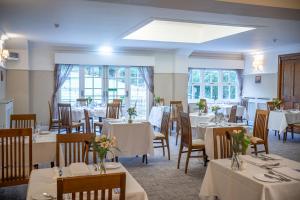 a dining room with white tables and chairs at Briery Wood Hotel in Ambleside