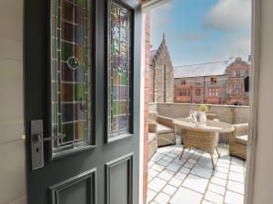 a door leading to a balcony with a table and a patio at 2 Llewelyn Street in Conwy