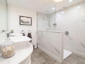 a white bathroom with a shower and a sink at 2 Llewelyn Street in Conwy +11 photos