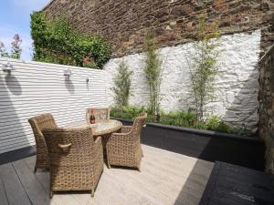 a patio with a table and chairs and a wall at 2 Llewelyn Street in Conwy