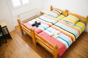 a bed with a colorful blanket and two crosses on it at Grand F2 Saint Maur in Saint-Maur-des-Fossés