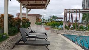 a resort patio with chairs and a swimming pool at Arc Tower Condominium 1930 and 1727 in Cebu City