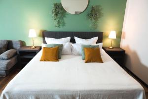 a bedroom with a large white bed with two lamps at Lakeside Lodge mit Seeblick am Kranichsee in Goslar