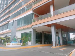a large building with a sign in front of it at Arc Tower Condominium 1930 and 1727 in Cebu City