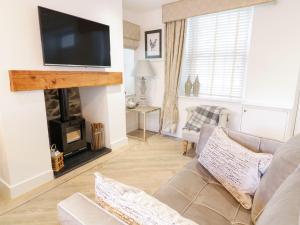 a living room with a couch and a fireplace at 8 Crown Lane in Conwy